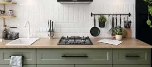 Moderne keuken met witte wandtegels, houten werkblad en groene keukenkastjes – stijlvolle en onderhoudsvriendelijke keukeninrichting.