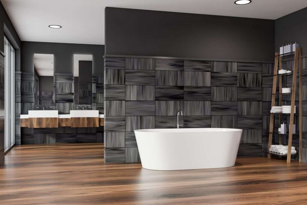 Moderne badkamer met vrijstaand bad, donkere wandtegels en houtlook vloertegels voor een luxe en warme uitstraling.