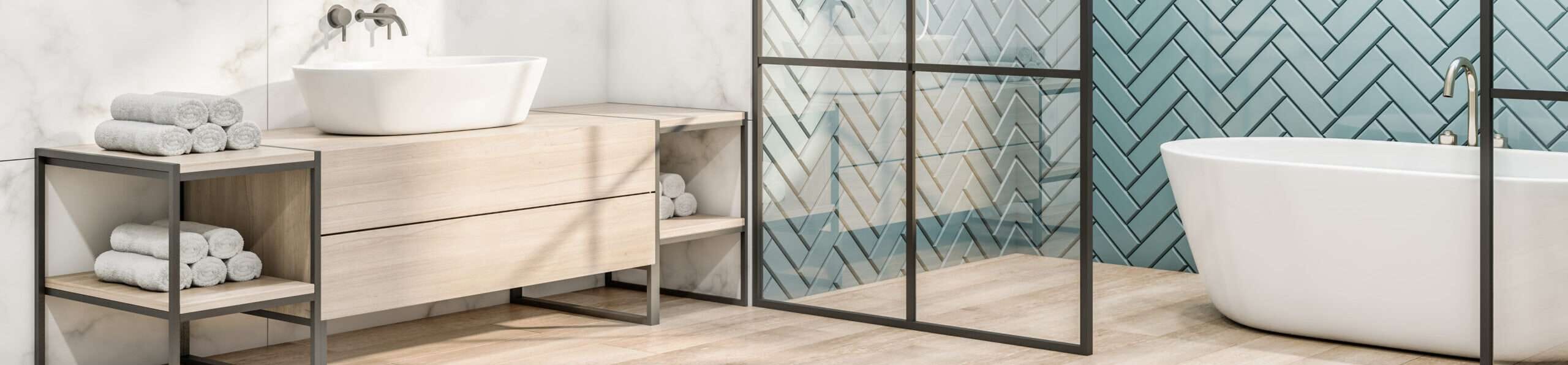 Moderne badkamer met licht houtlook badkamermeubel, witte waskom, vrijstaand bad en blauwe wandtegels in visgraatpatroon achter glaswand – inspiratie voor stijlvolle badkamer met visgraat tegels en natuurlijke materialen.