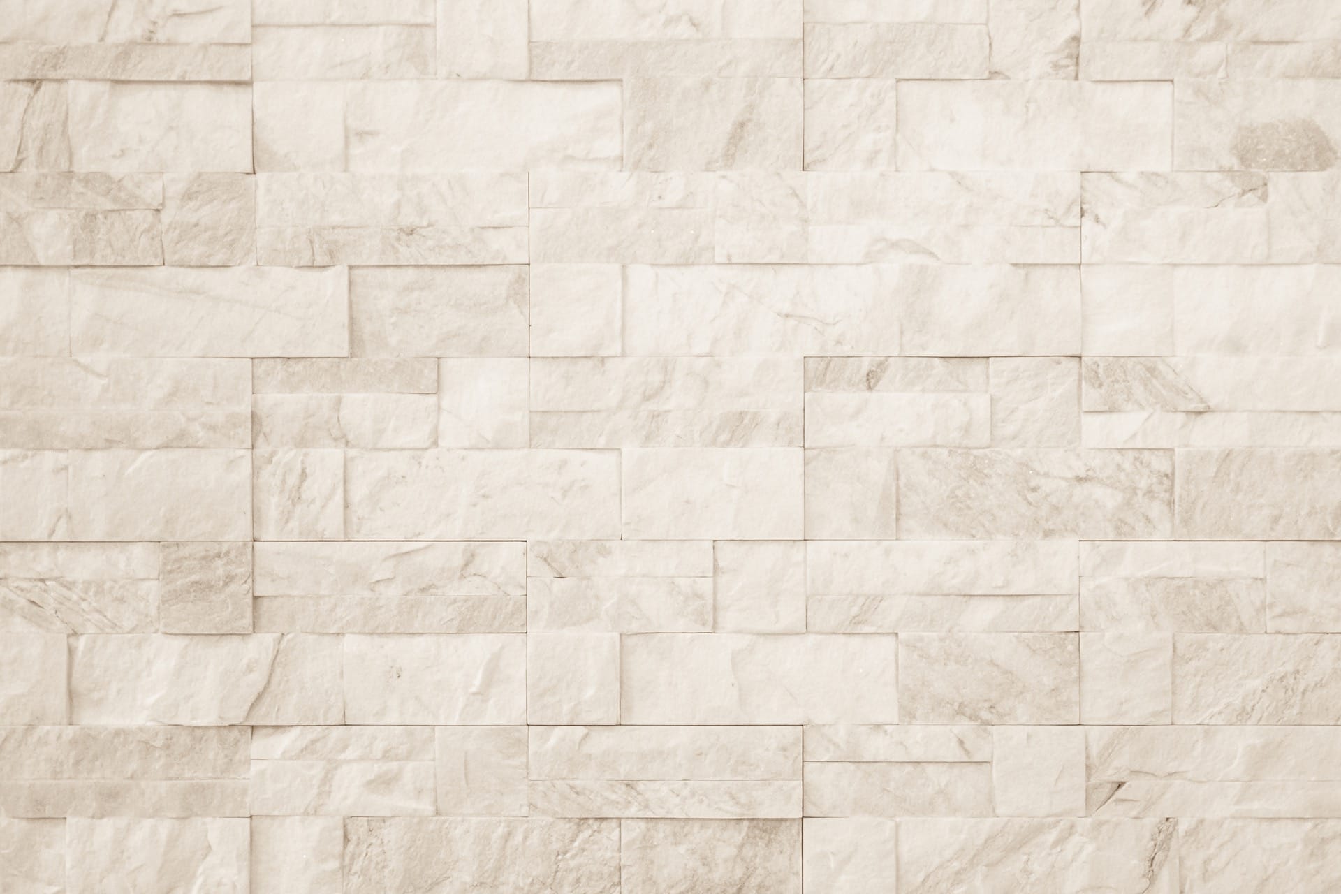 Wand met beige natuursteenlook tegels gelegd in Romaans verband, inspiratie voor wandtegels met klassiek legpatroon