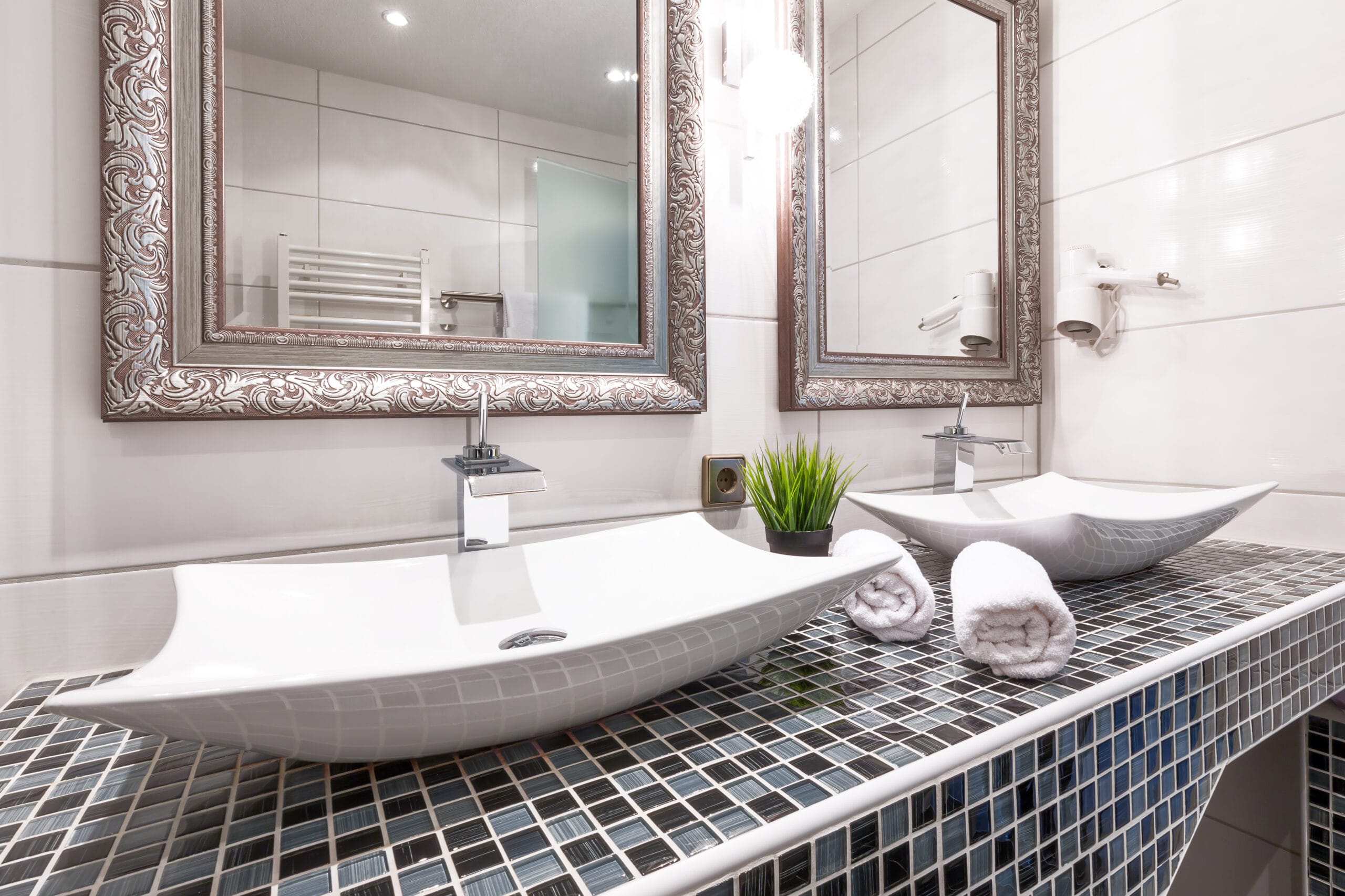 a bathroom with two sinks and two mirrors